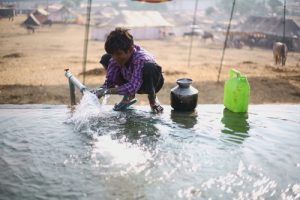 Niño cogiendo agua de un pozo